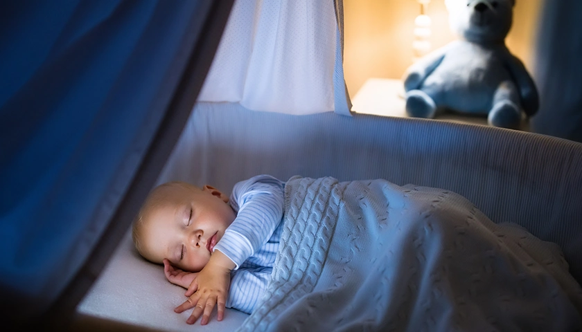 Bebé durmiendo en la cuna con un humidificador en la habitación. en aposán sueño de calidad