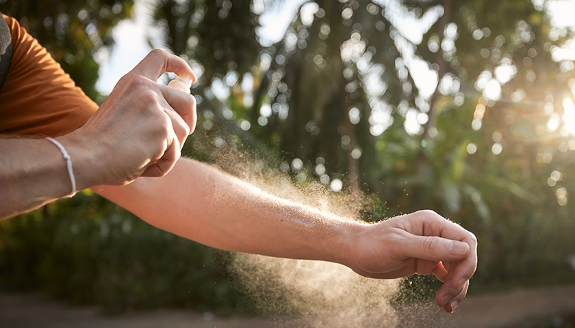 Hombre echándose repelente de insectos para prevenir las picaduras de mosquitos en verano (1). con aposán previenes picaduras